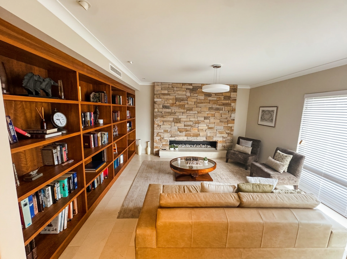 Wide living room with timber shelving and stone fireplace